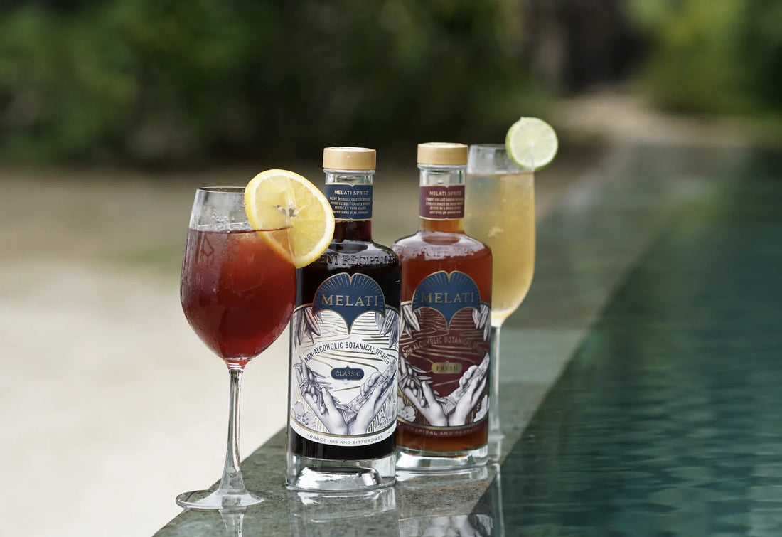 Melati Drinks Classic and Fresh bottles beside citrus-garnished botanical serves by the pool.