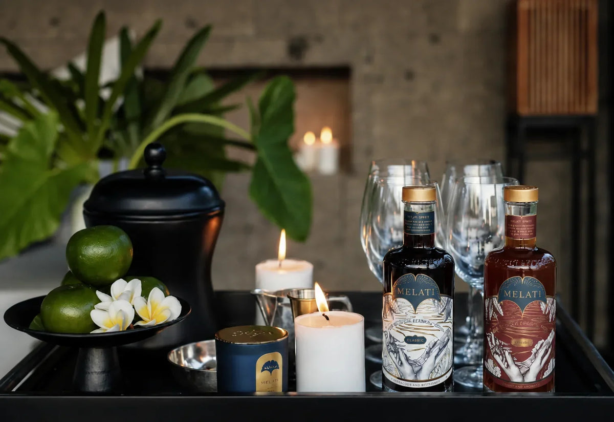 Melati Drinks Classic and Fresh bottles styled with citrus, flowers, candles, and glassware.